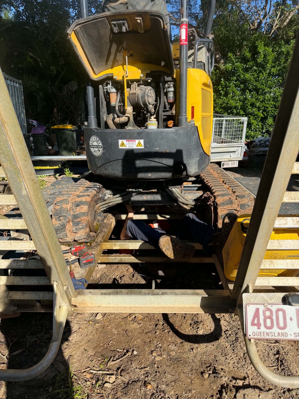 Trade qualified fitter working under a machine on site on the Sunshine Coast